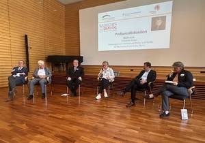 Quelle: Katholische Akademie der Erzdiözese Freiburg Drei Männer und zwei Frauen sitzen im Halbkreis in der Aula und diskutieren.