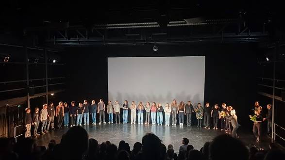 Viele Schülerinnen und Schüler stehen auf der Bühne im Halbkreis